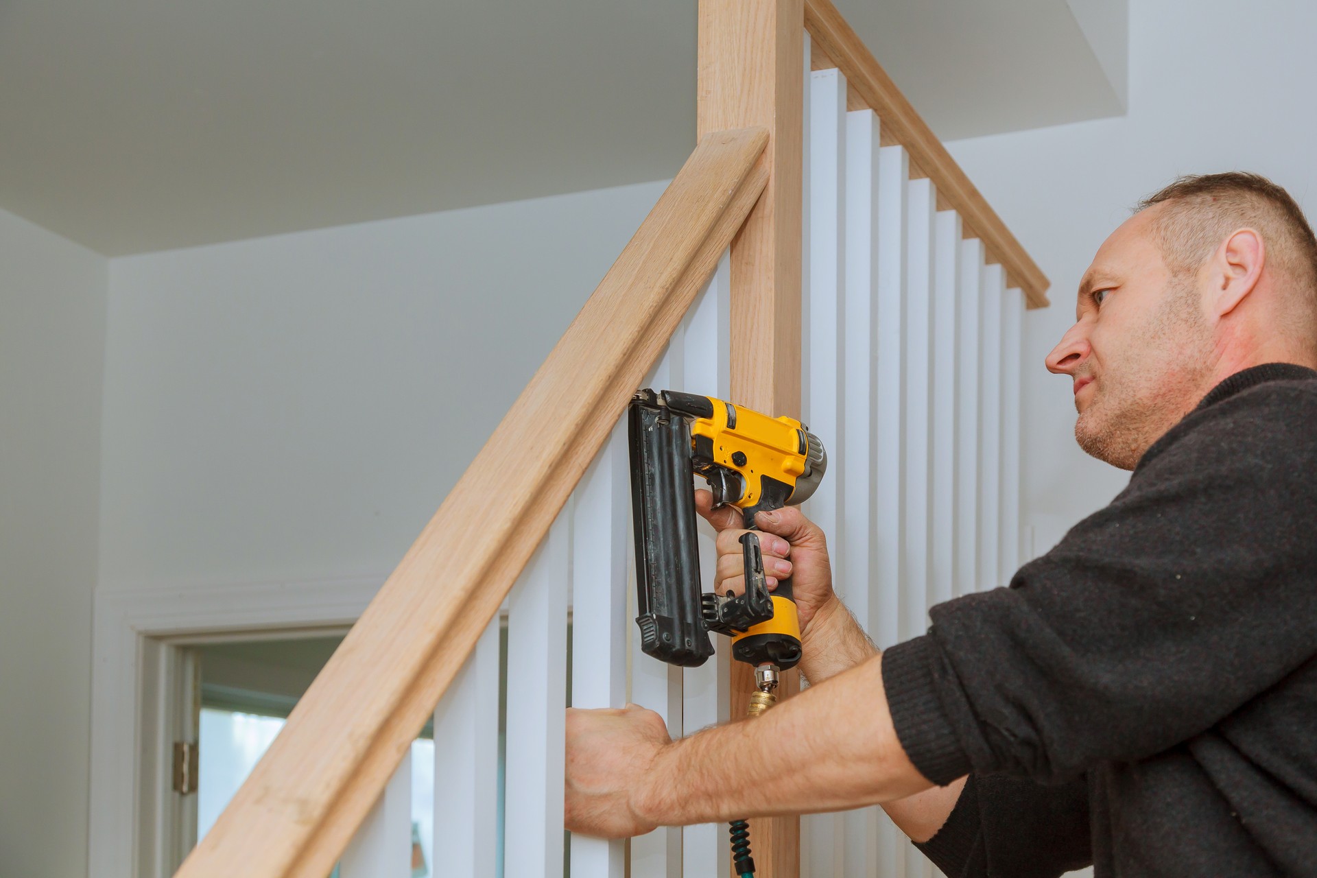 Installation nailing the railing for stairs with an air gun wooden railing