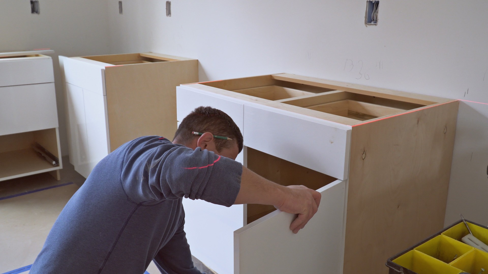 worker installing kitchen cupboard